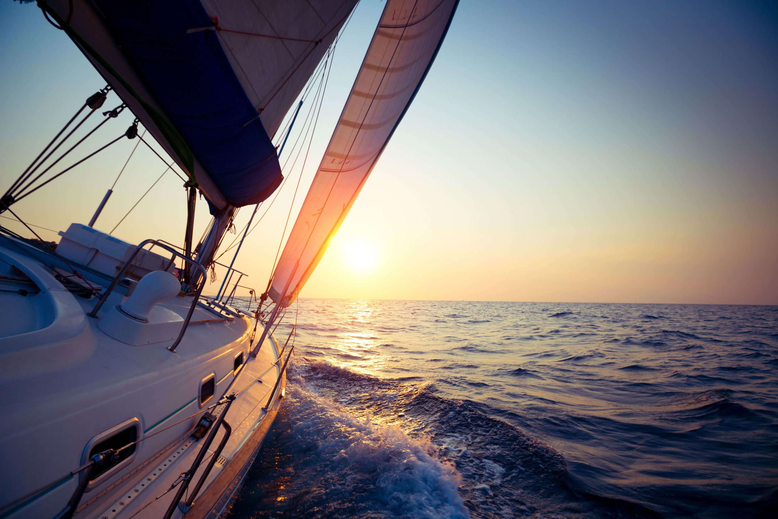 Yacht sailing through clear waters symbolising a wealth management firm guiding clients to making the right decisions